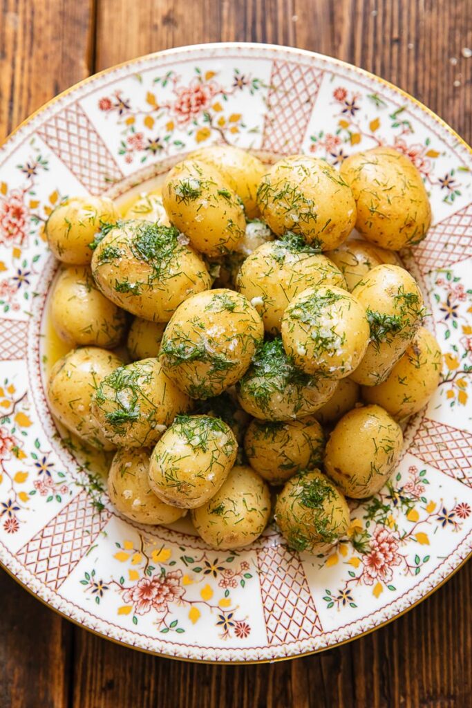 Top down shot of new potatoes with garlic butter on a plate