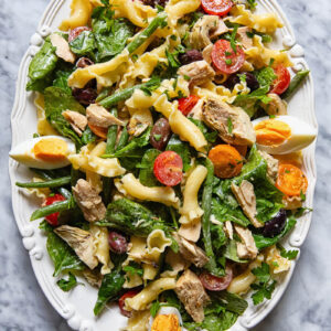 Top down shot of Nicoise pasta salad on a serving platter