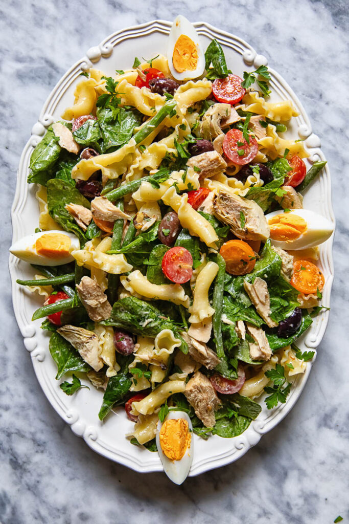 Top down shot of Nicoise pasta salad on a serving platter