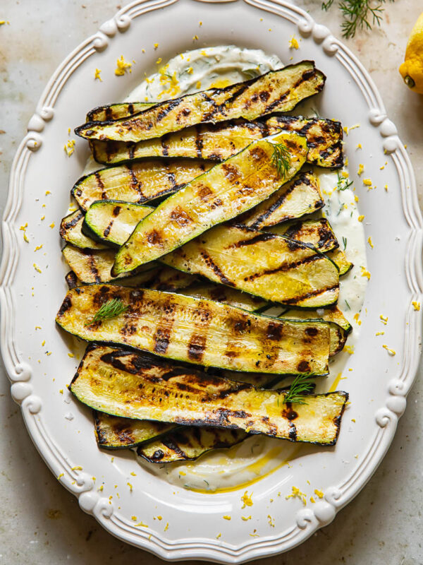 vertical shot of grilled zucchini on a bed of whipped feta