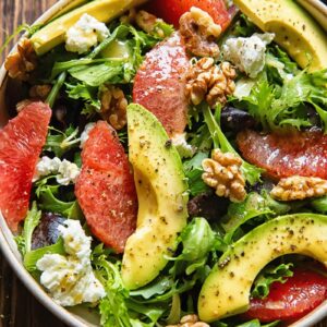 A dish of autumn salad with grapefruit, avocado and goat cheese.