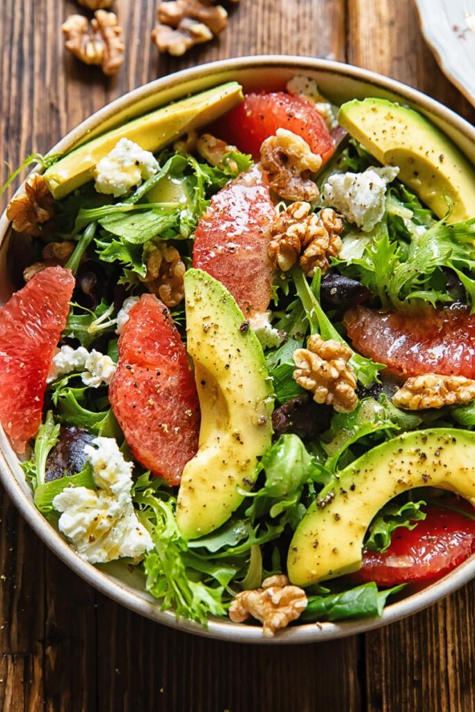 A dish of autumn salad with grapefruit, avocado and goat cheese.